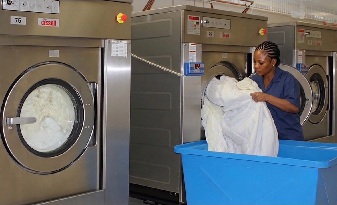 Crisp & Stitch team member sorting freshly washed linens into a cart